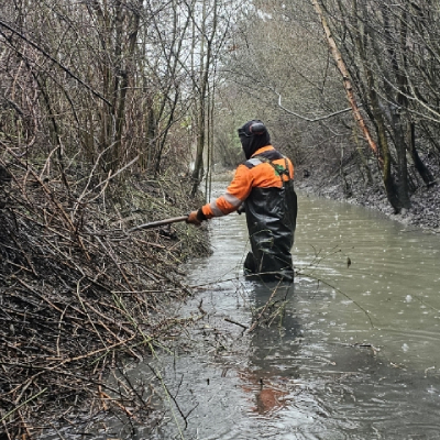 landscaper-clearing-stream-feature Landscaper clearing stream